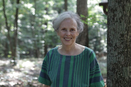 Portrait of Ina May Gaskin, pioneer of modern midwifery, standing outdoors at The Farm in Tennessee.