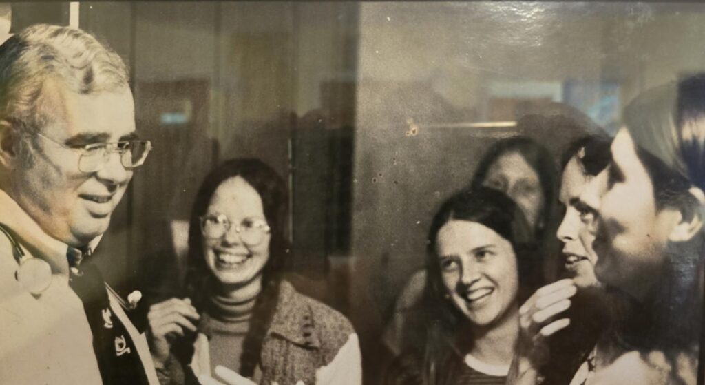 Historical black-and-white photo of Ina May Gaskin and The Farm midwives in conversation at The Farm Midwifery Center.