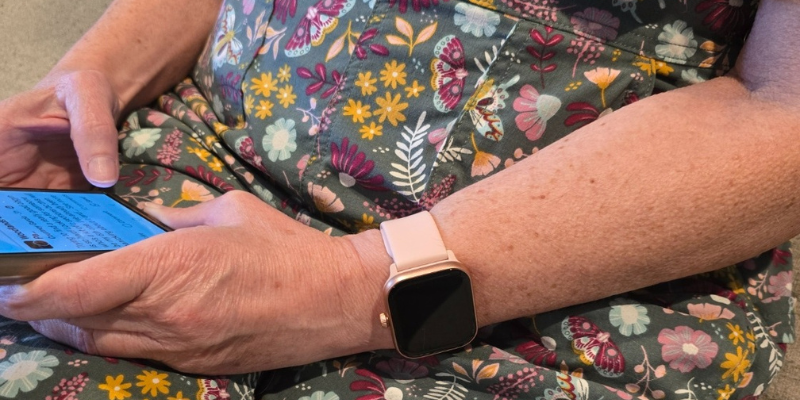 Woman using smartwatch and smartphone for health tracking insights